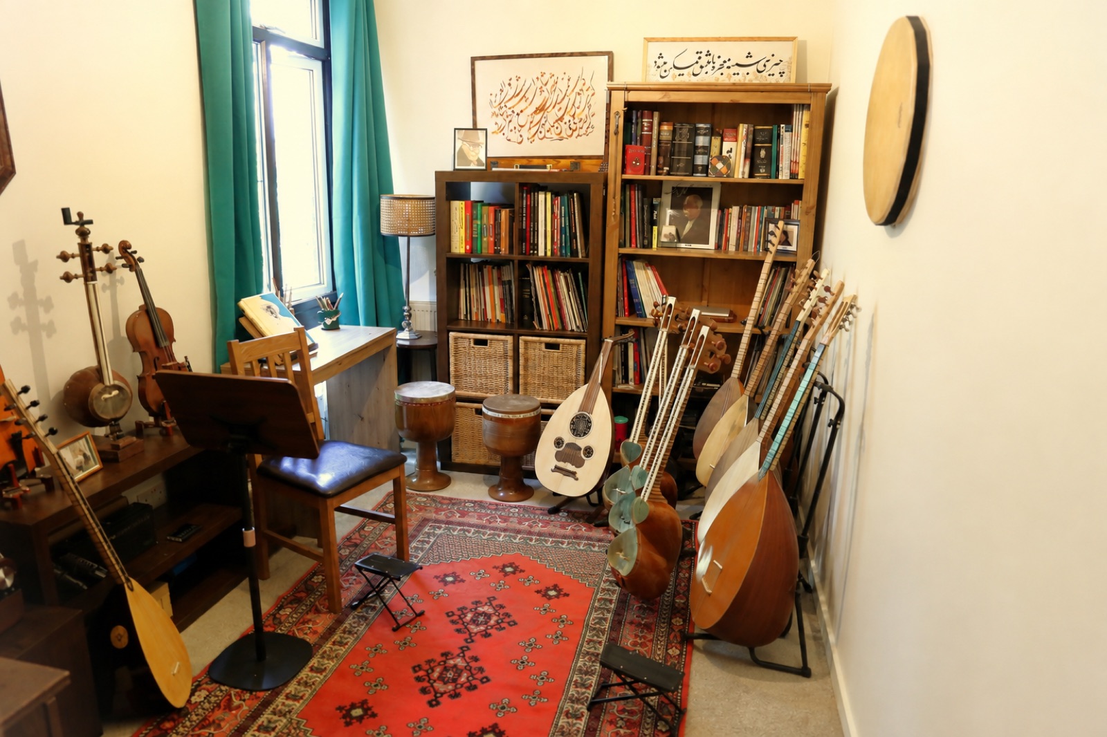 The teaching room: instruments on stands, shelves of books and scores, a rug on the floor